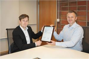 Knut Omberg, Principal Engineer at DNV GL – Maritime (left), presents Roar Simensen, Product Adviser - Connected Vessels & Information management at Kongsberg Maritime (right), with the new type approval. (Photo: DNV GL)